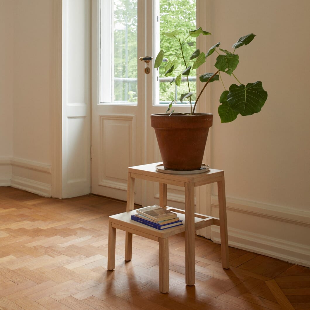 solid krakk i eik som brukes som sidebord med en plante i krukke.