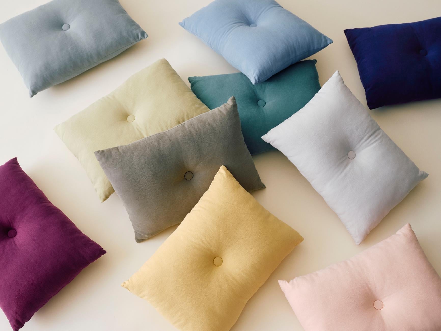 Dekorative puter i myke tekstiler og rolige fargetoner, arrangert sammen for å vise hvordan puter kan kombineres i stuen.