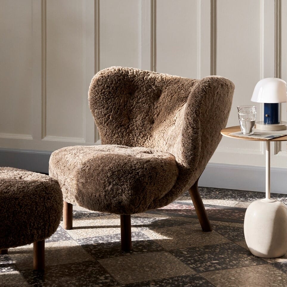 Brun designklassikeren Lille Petra lenestol i saue ull stoff i en klassisk stue