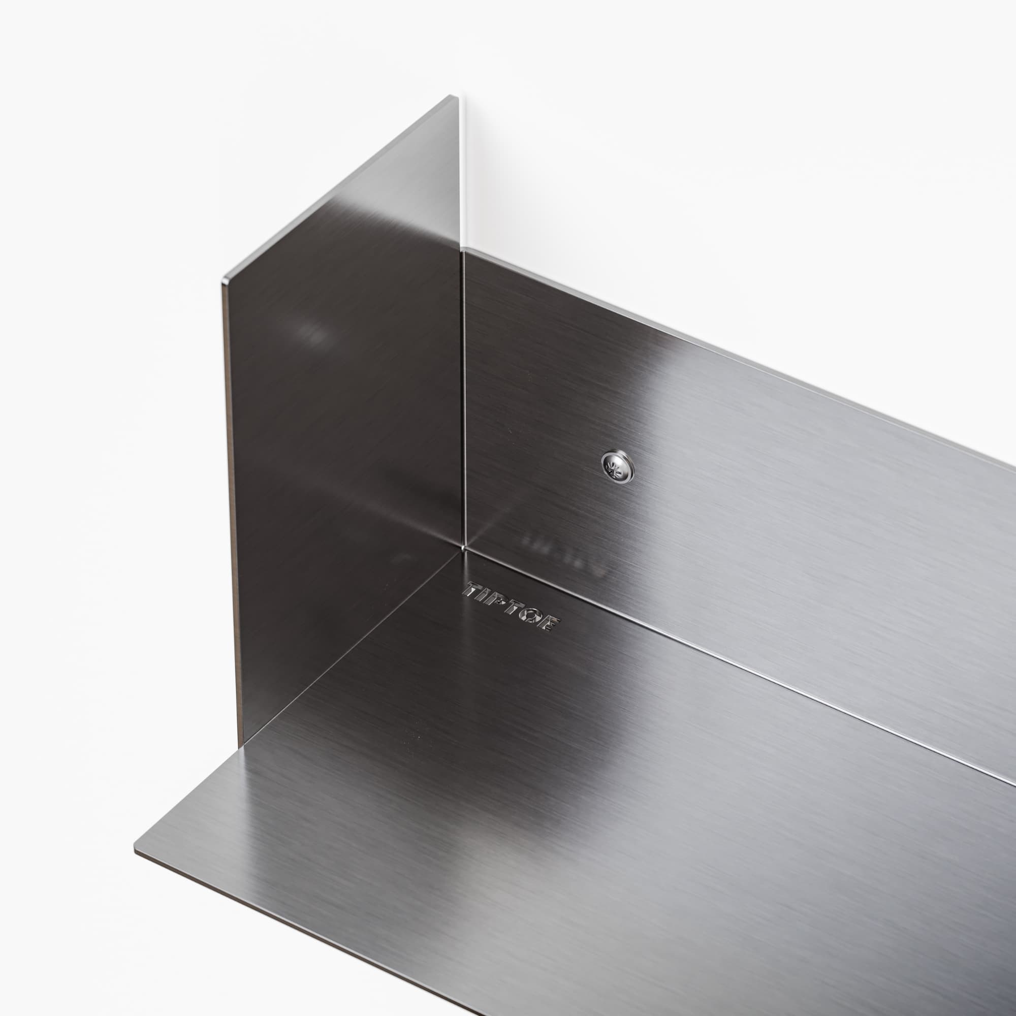 Detalj av minimalistisk vegghylle i børstet stål.