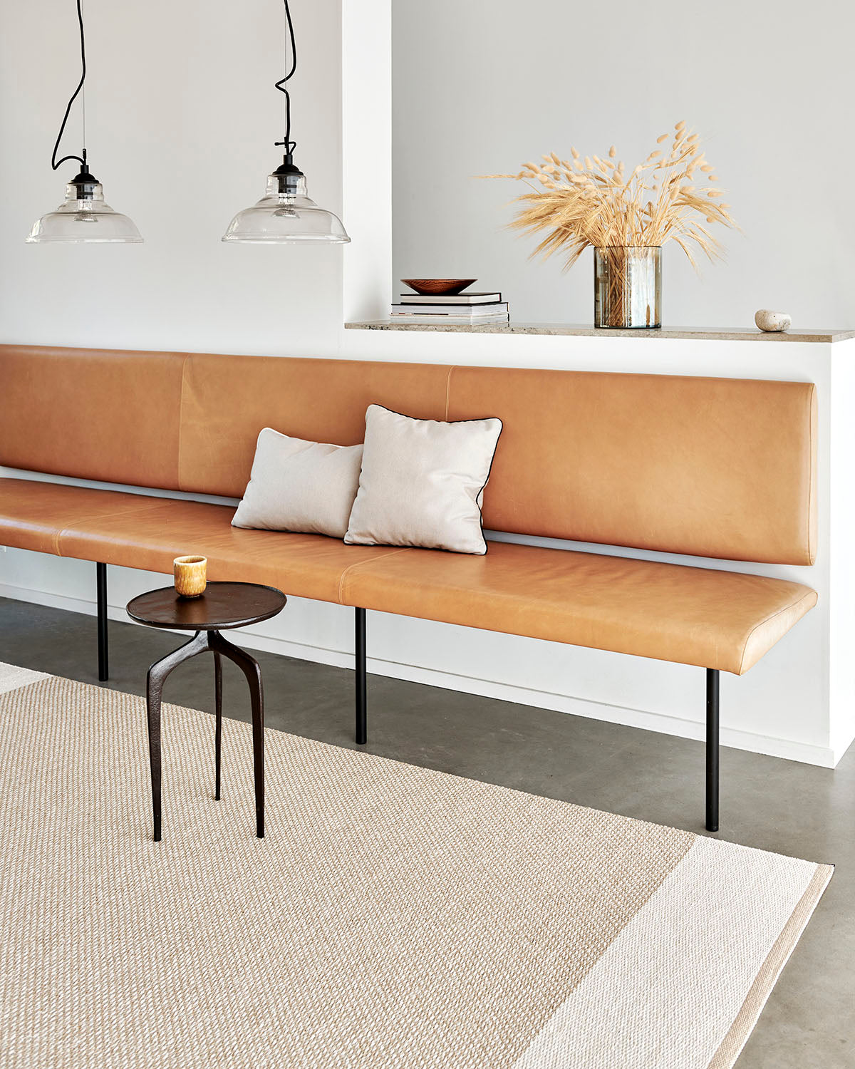 Pappelina Edit Beige under en benk i stue