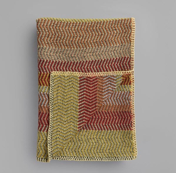 Person holder Fri Summer Red ullpedd med sikksakkmønster sammenfoldet