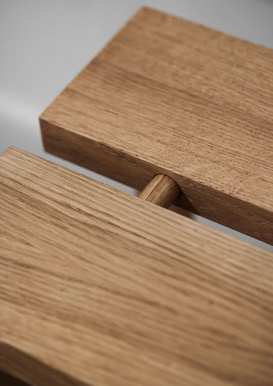 Nærbilde av sammenføyning i massiv eik, som viser treplugg og detaljert håndverk på Moebe Peg benk.