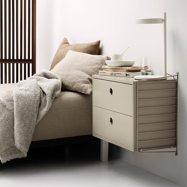 Vegghengt nattbord fra String med skuff ved siden av seng