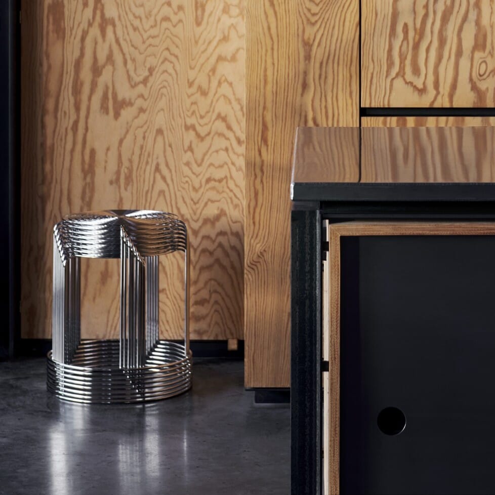 Wire Stool VP11 krakk i speilblankt stål stablet oppåhverandre vist i et kjøkkenmiljø med vegger av tre