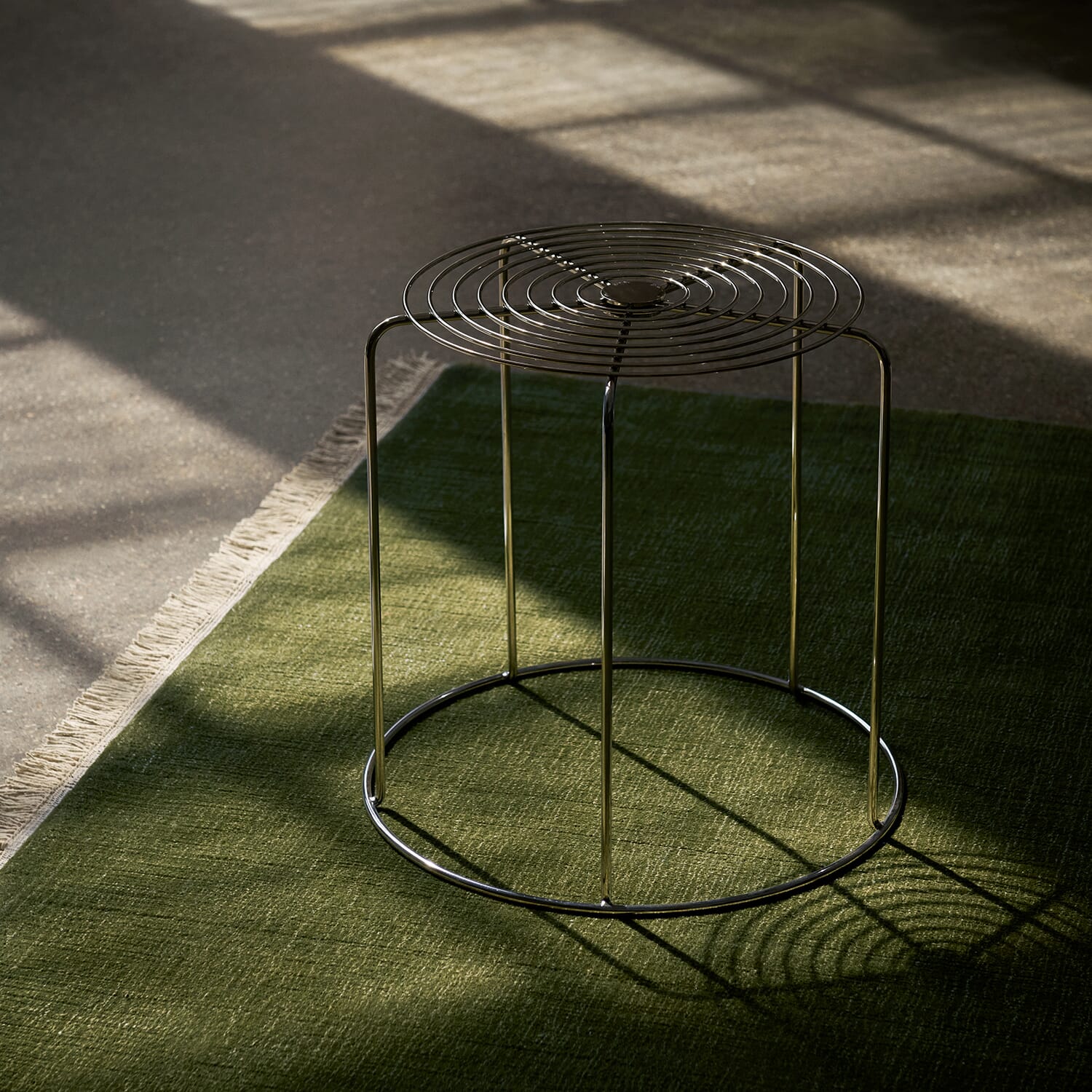 Wire Stool VP11 krakk i rustfritt stål designet av Verner Panton på et grønt teppe