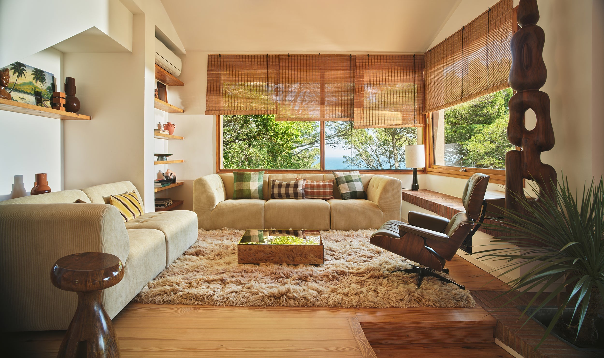 Dekorative vaser og fat i keramikk og metall på et rundt bord dekket med blondeduk, i et kunstnerisk og vintage-inspirert interiør.