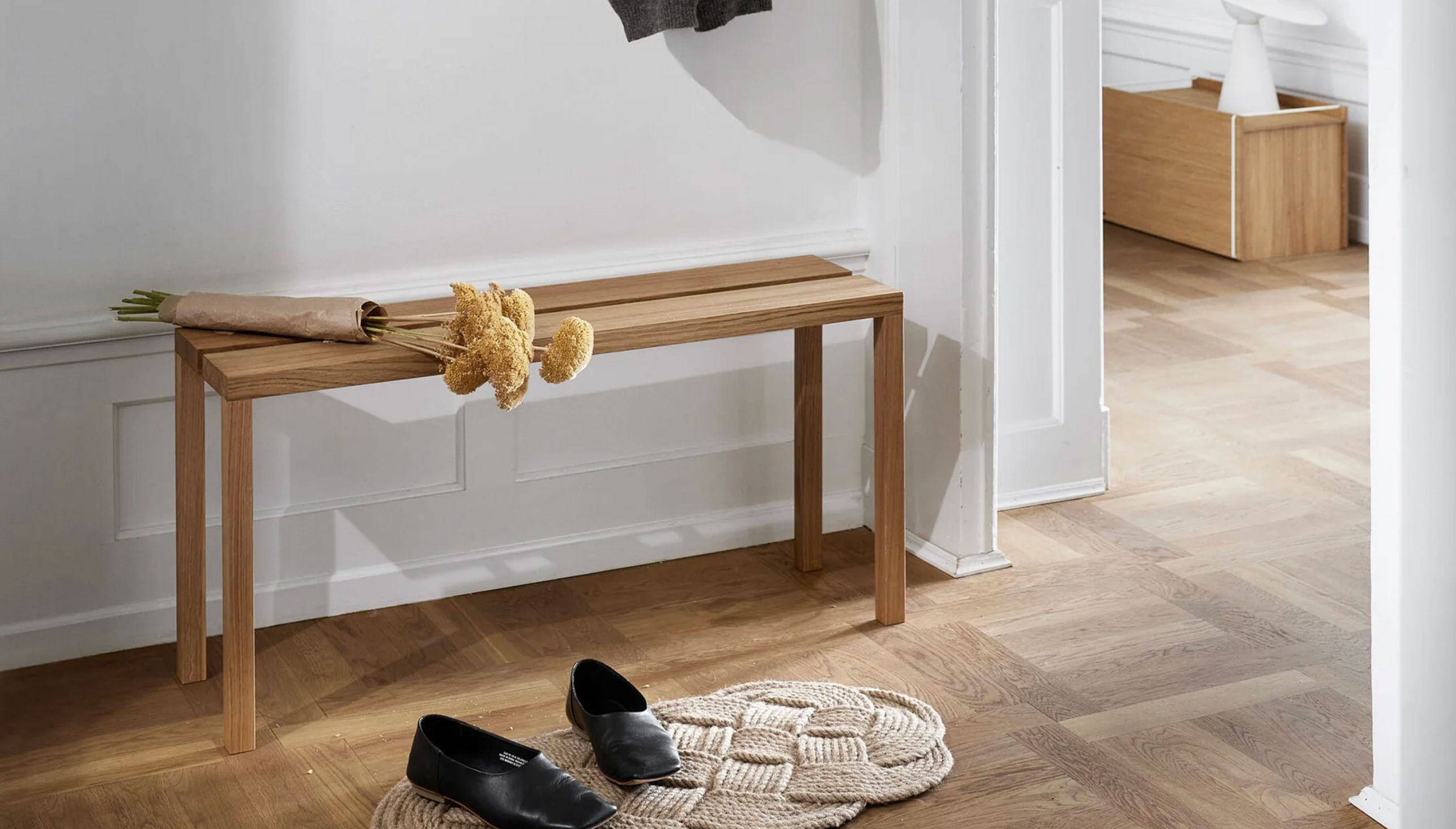 Benk i eik står langs veggen i gangen i et klassisk norskt hjem.