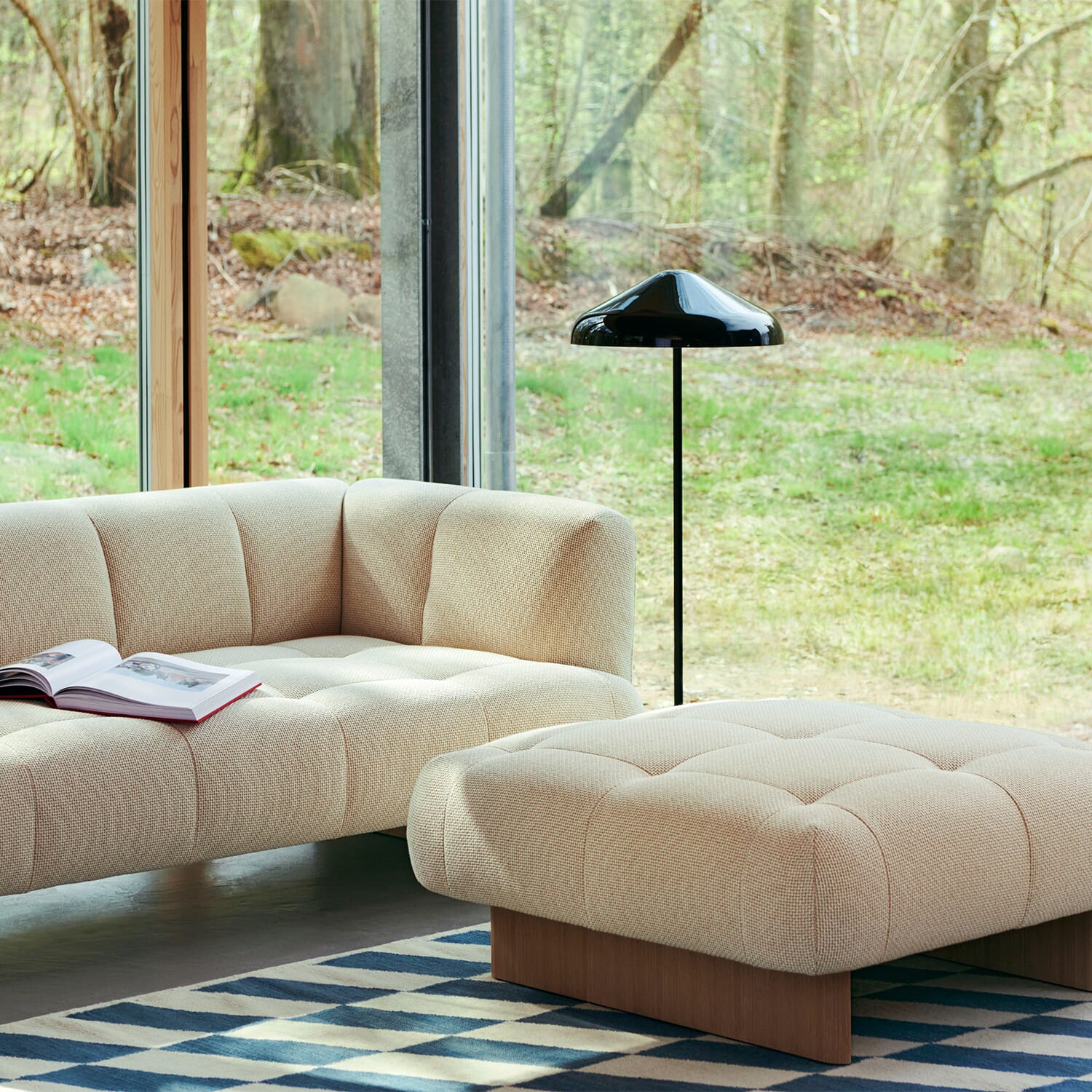 Beige Muuto-sofa med puff i moderne stue.