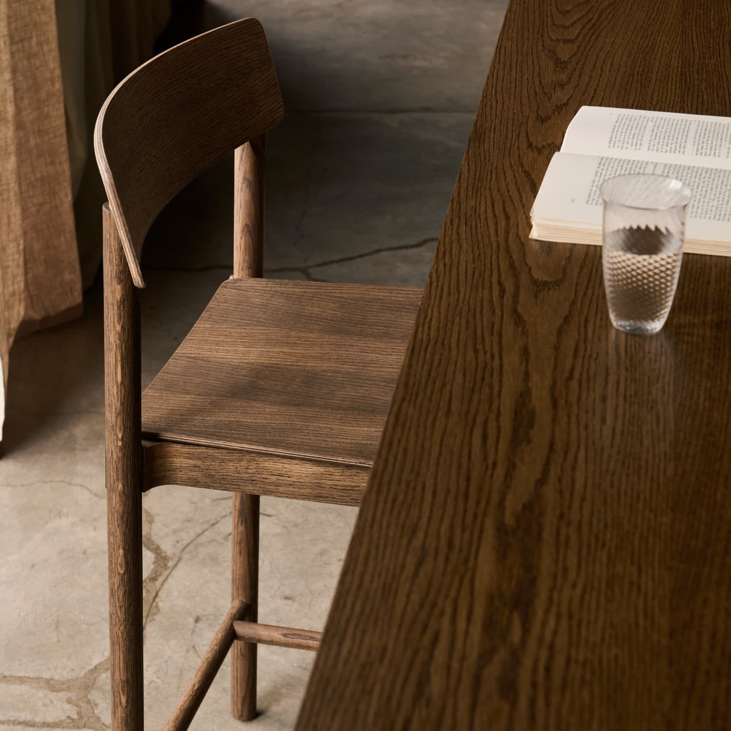 Detalj av Betty Barstol TK13 i røkt eik med detalj av rygg og materialstruktur ved kjøkkenbenk