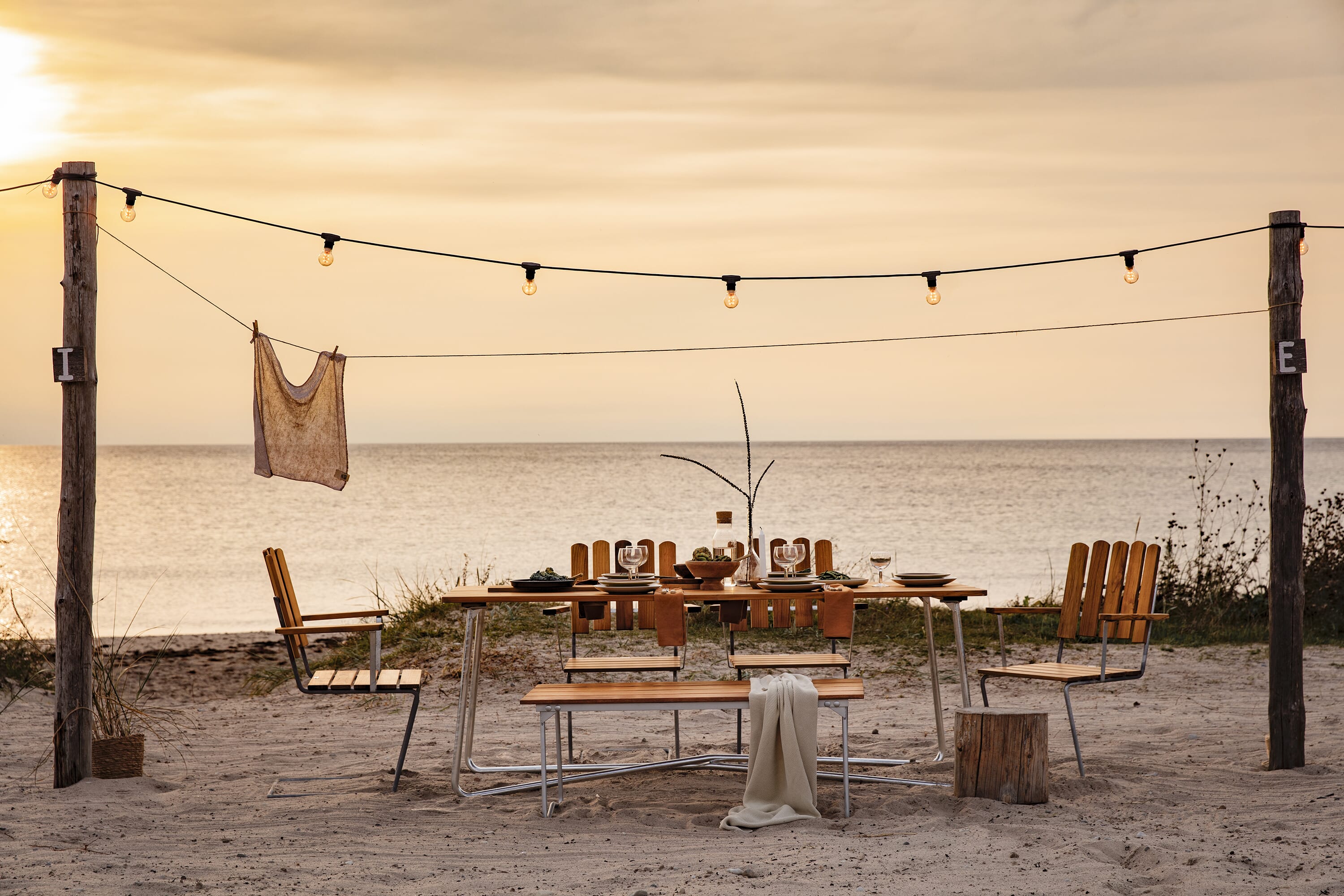 Klassiker A2 Spisestol teak i en spisegruppe på stranden