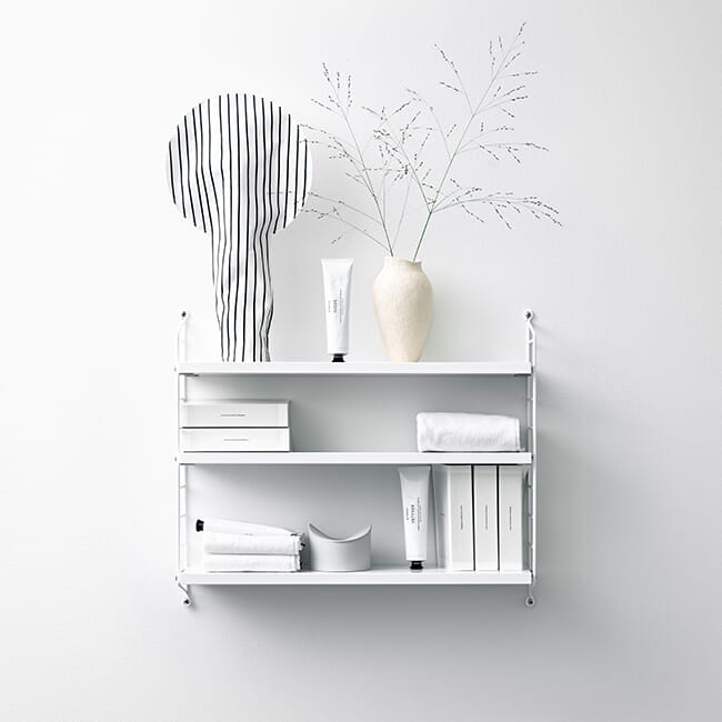 String Pocket hvit hylle med interiørdetaljer på veggen